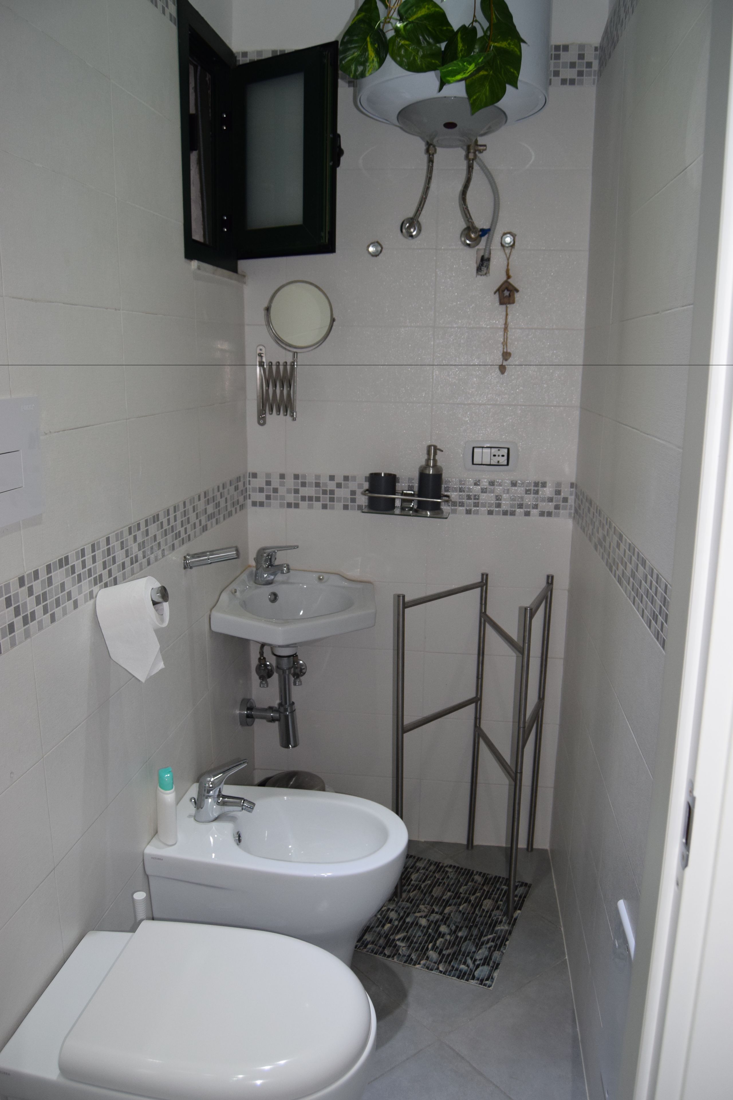 Un baño pequeño con inodoro, bidé y lavamanos.
