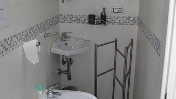 Un baño pequeño con inodoro, bidé y lavamanos.