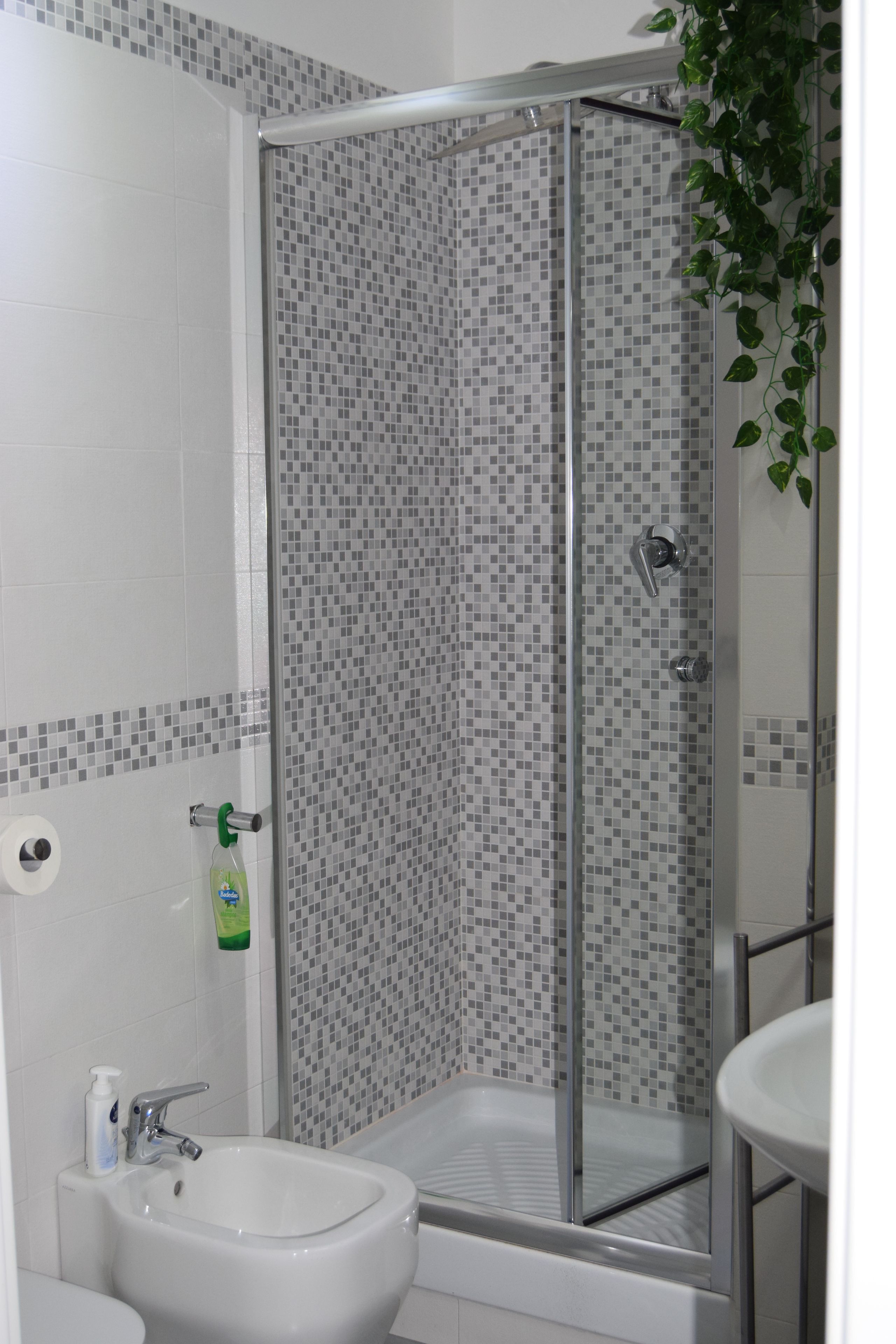 A bathroom with a shower, sink, and toilet.
