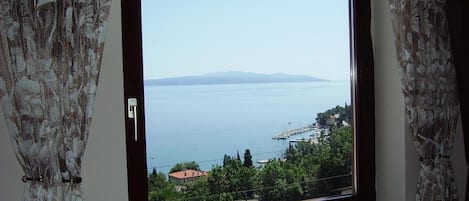 A room with a large window overlooking a coastal view.