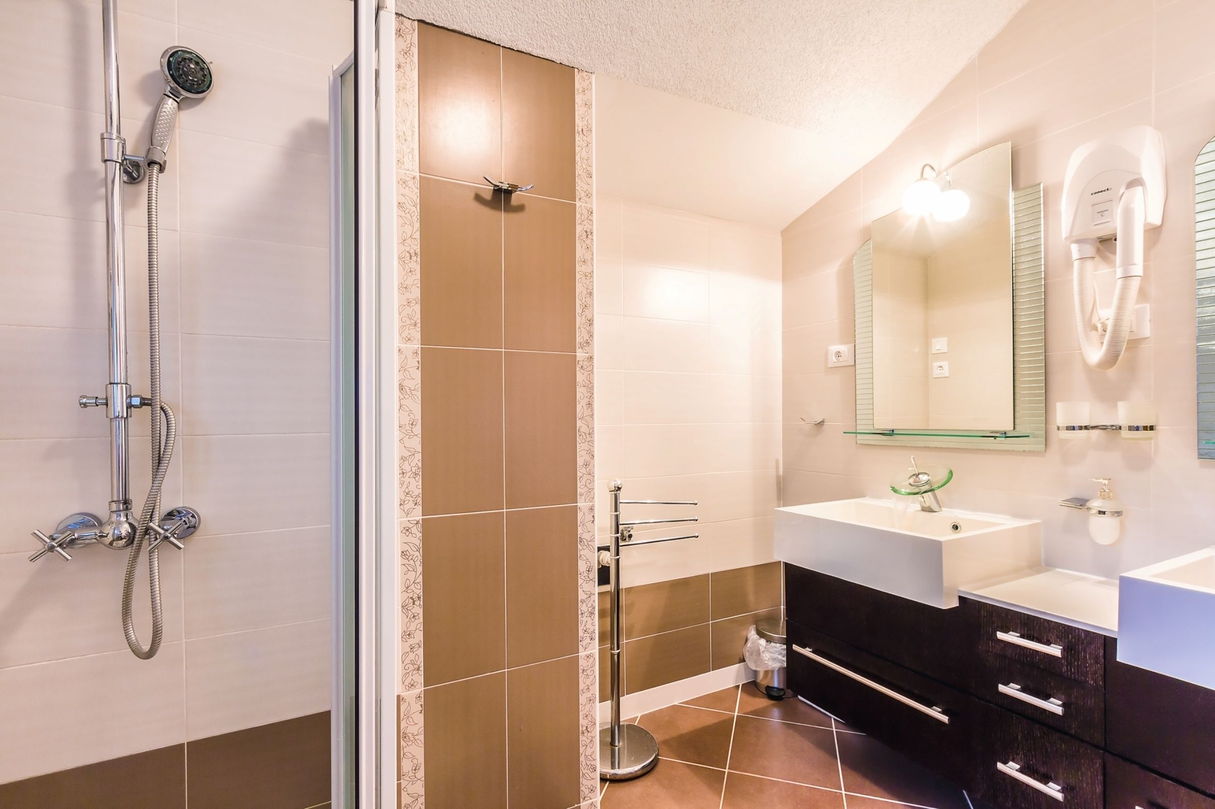 A modern bathroom with a shower, a sink, and a vanity.