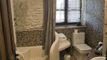 A bathroom with a bathtub, toilet, and sink.