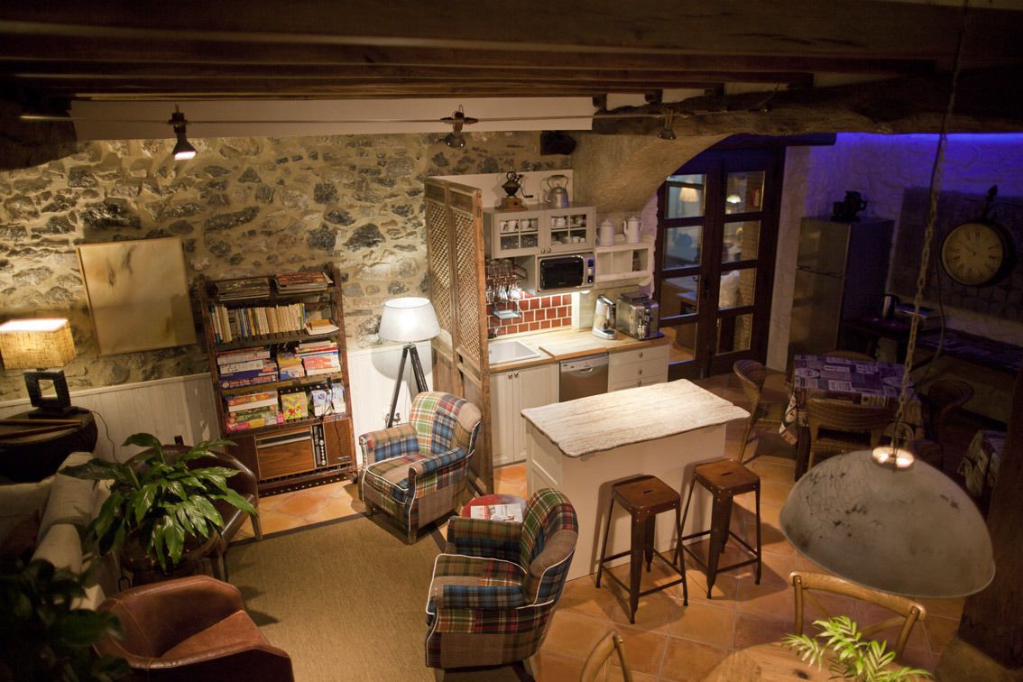 Una cocina rústica con paredes de piedra, muebles de madera y un pequeño comedor.