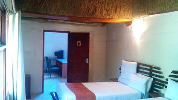 Una habitación con dos camas, un escritorio y una silla.