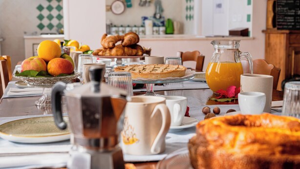 A breakfast table with pastries, fruits, and a pitcher of orange juice. - B&B Belvedere (Agropoli)
