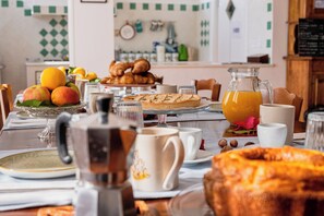 A breakfast table with pastries, fruits, and a pitcher of orange juice. - B&B Belvedere (Agropoli)