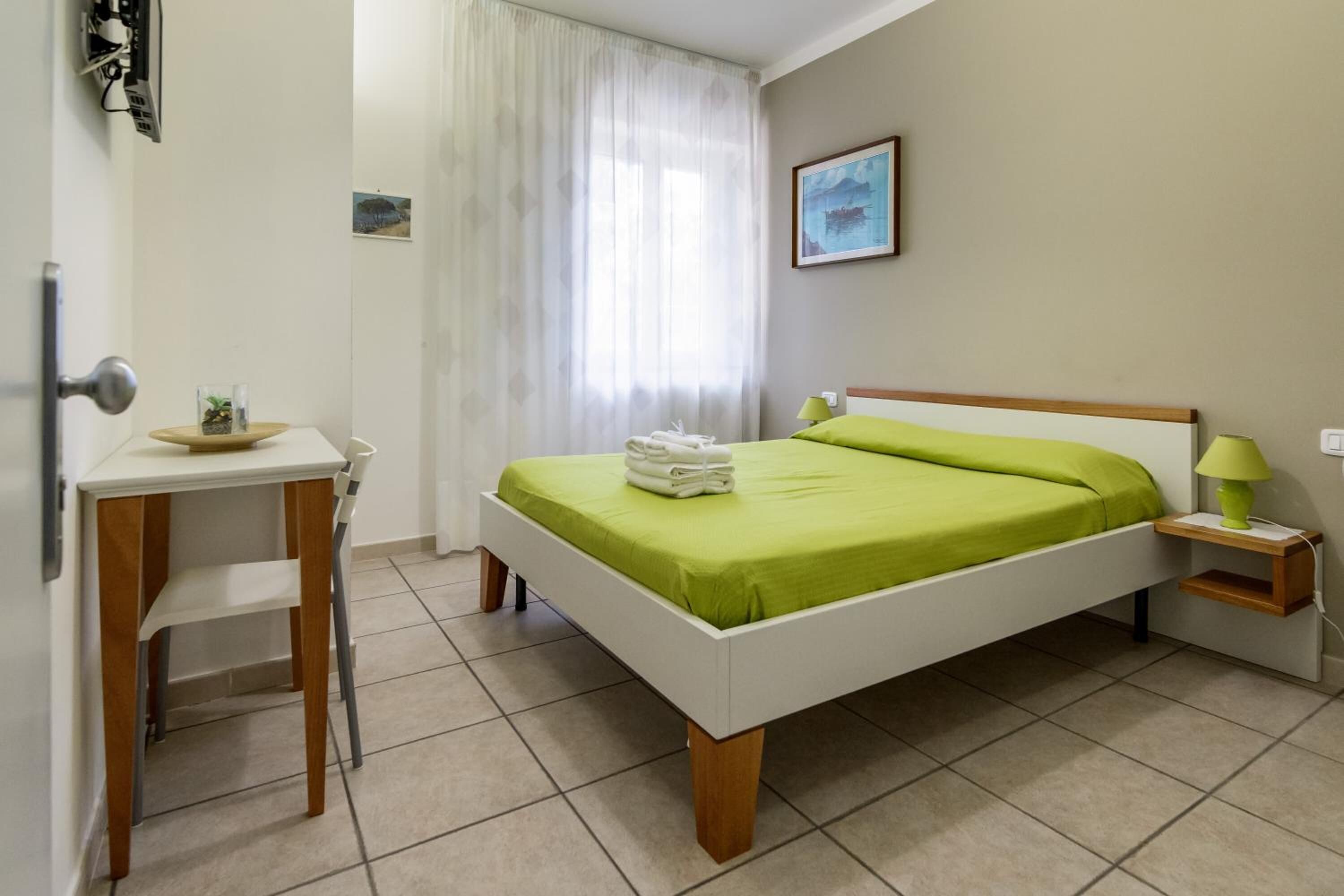 Un dormitorio con cama, escritorio y silla.