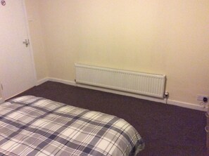A bedroom with a bed, a radiator, and a door. - The L6 Guest Rooms (Liverpool)