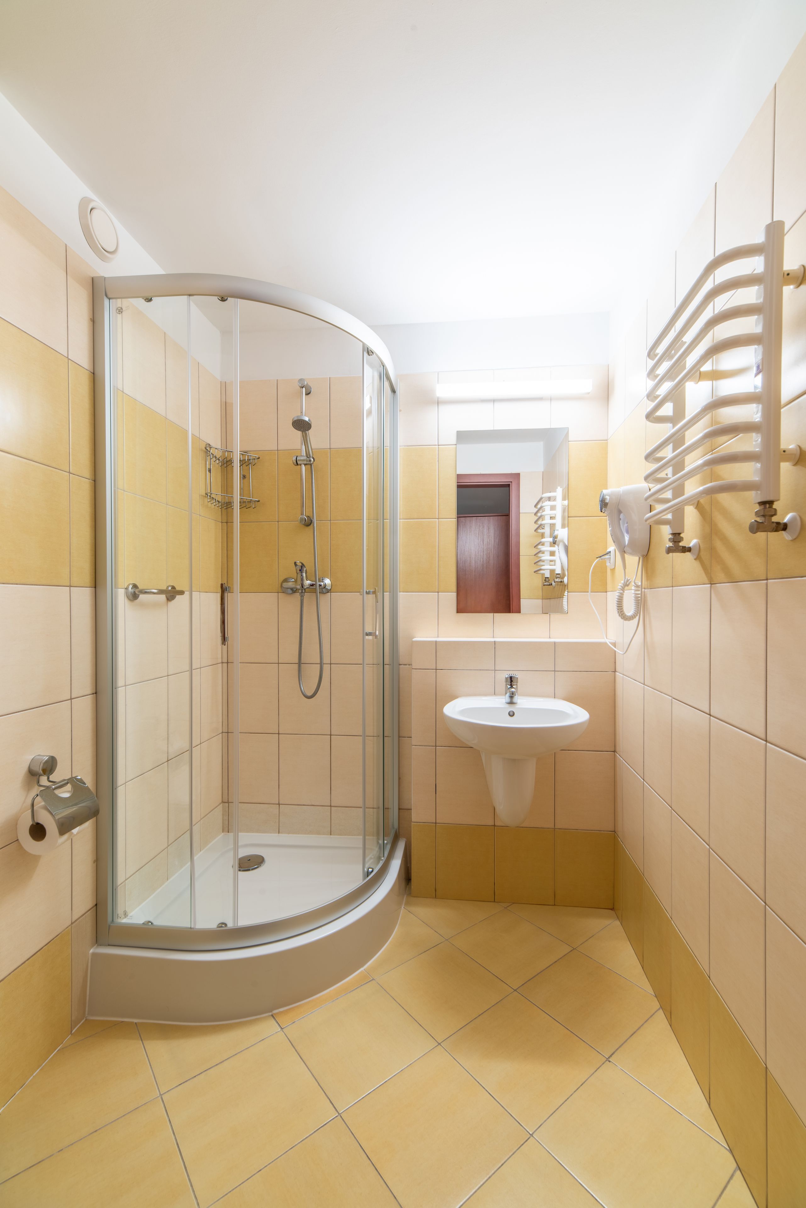 Une salle de bain avec une douche à parois de verre, un lavabo et un porte-serviettes.