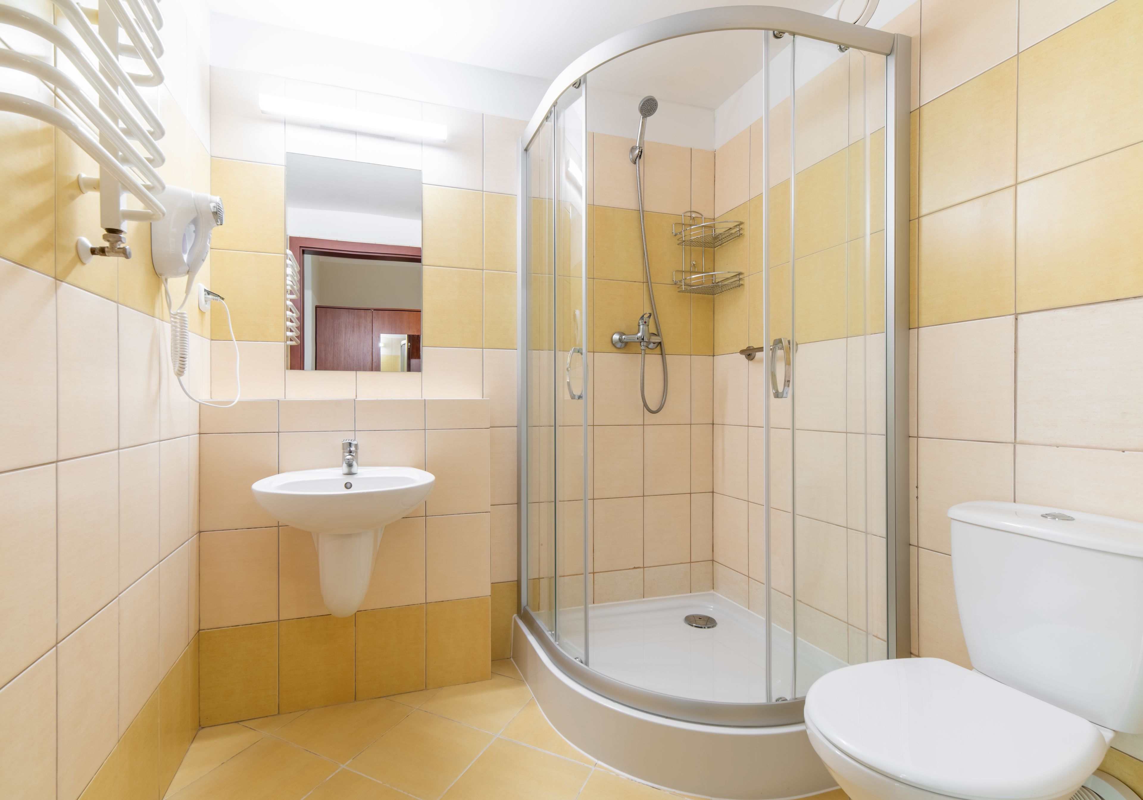 A bathroom with a shower, sink, and toilet.