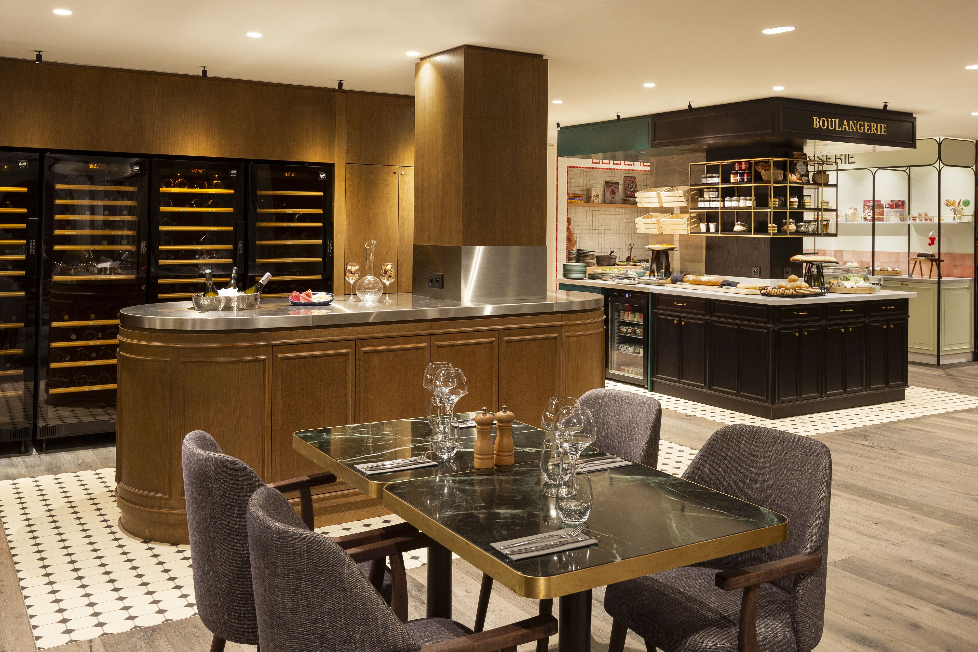 Une cuisine moderne dotée d’un îlot central, de meubles en bois et d’une palette de couleurs comprenant le noir et l’or.