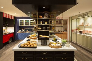 A bakery display with various breads and pastries, a coffee station, and a patisserie section.