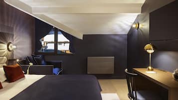 Un dormitorio moderno con una cama grande, un escritorio y una silla. Hay una ventana con vistas al exterior.
