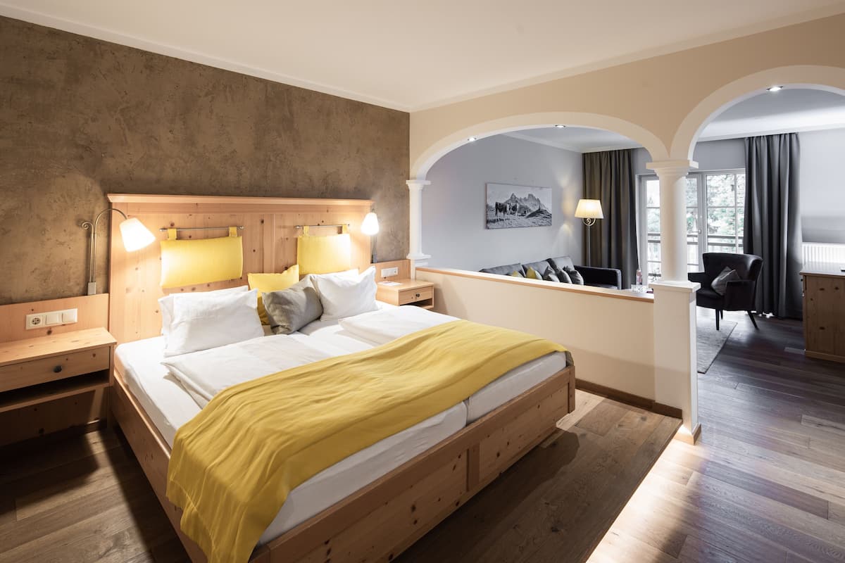 A hotel room with a wooden bed, a desk, and a chair.