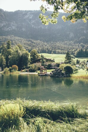 A lakeside view with a house, dock, and surrounding greenery. - Post Family Resort (Unken)
