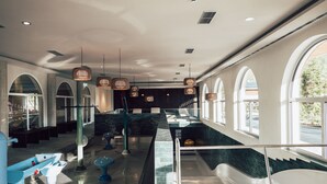 A spacious lobby with a central water feature, large windows, and modern lighting fixtures. - Post Family Resort (Unken)