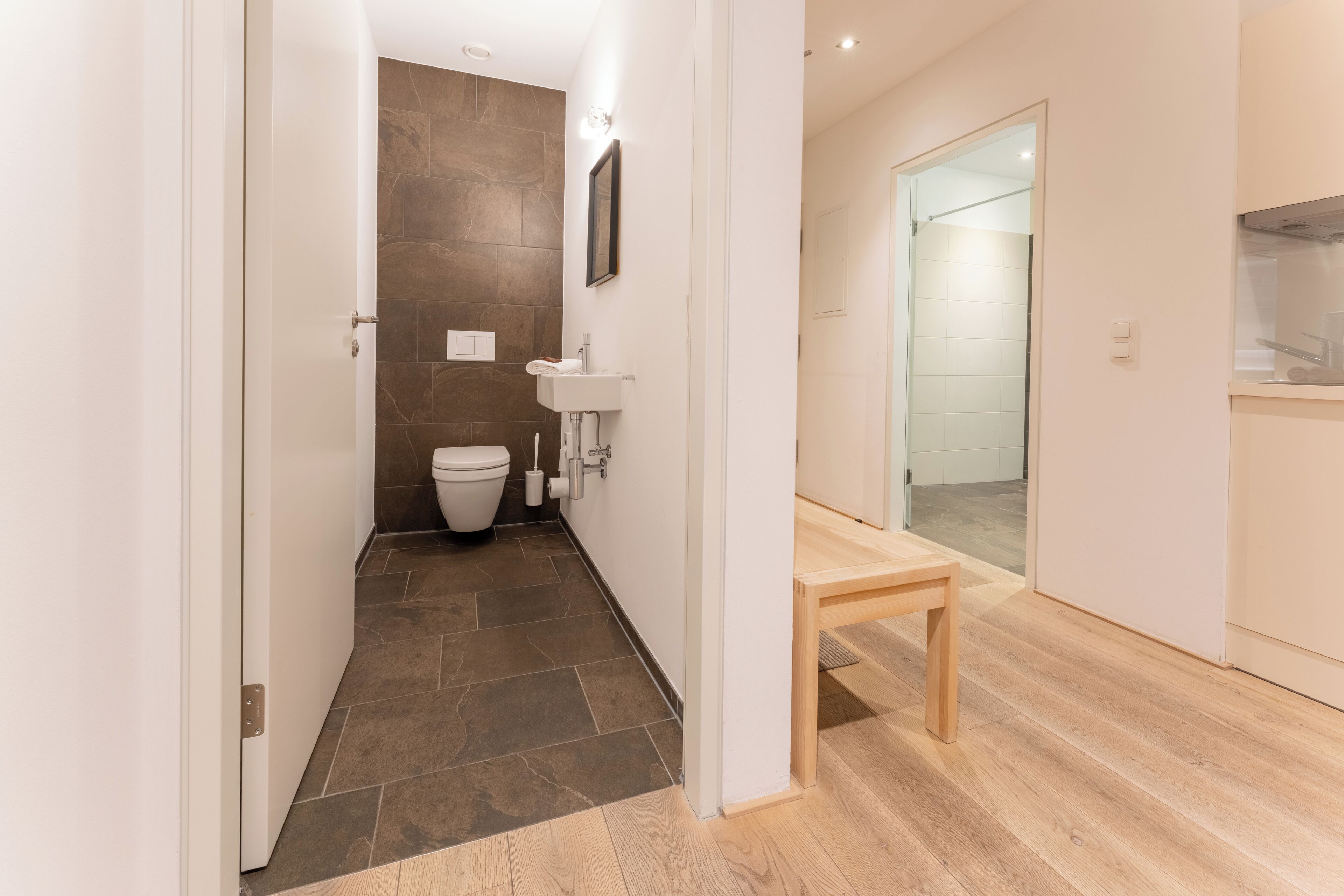 A modern bathroom with a toilet, sink, and shower.