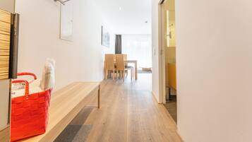 Simple, clean design with a wooden dining table and chairs, a comfortable bench, and a large window.