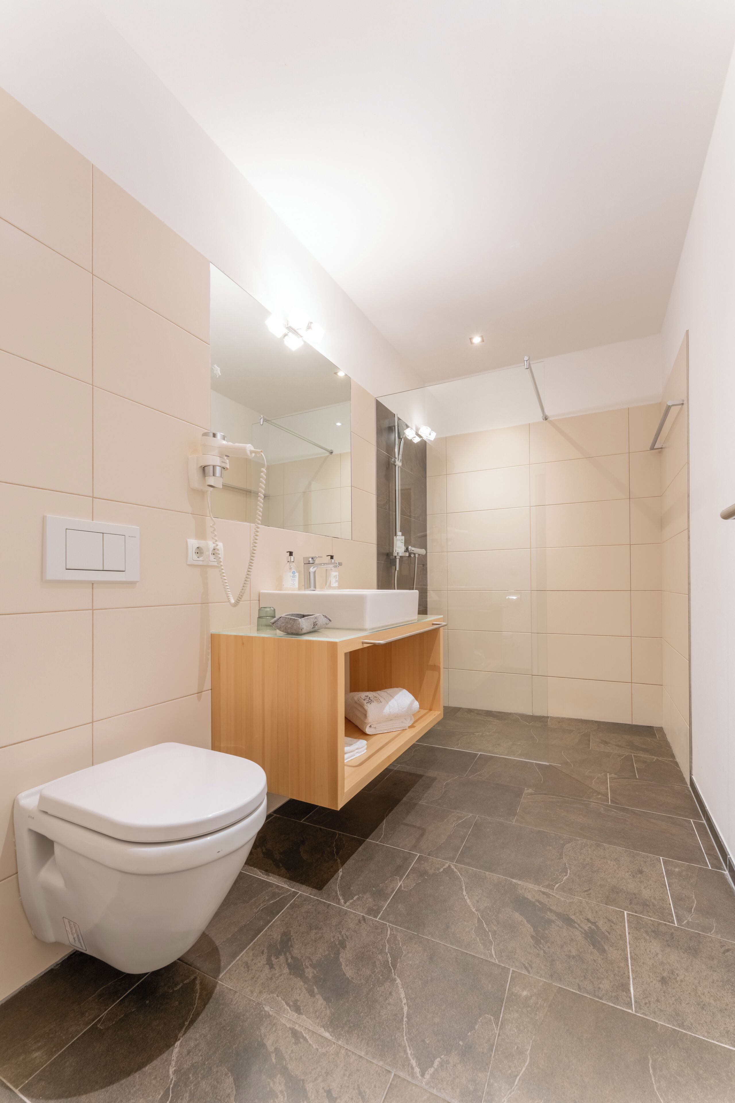 Un baño moderno con inodoro, lavabo y ducha.