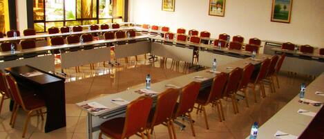 A conference room with a long table, chairs, and water bottles.