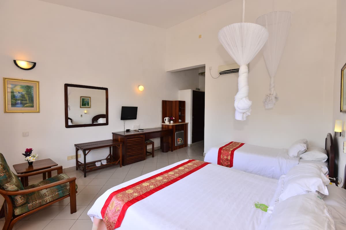 Una habitación de hotel con cama, escritorio, silla y televisor.