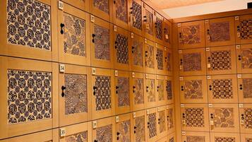 A row of wooden lockers with intricate designs and numbered tags.