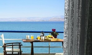 Une table dressée avec des aliments pour le petit-déjeuner, offrant une vue sur la mer.
