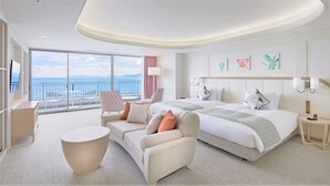 A modern hotel room with a large bed, a sofa, a round table, and a balcony with a view of the sea. - Karatsu Seaside Hotel (Karatsu)