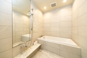 A modern bathroom with a large bathtub, a shower, and a mirror. - Karatsu Seaside Hotel (Karatsu)