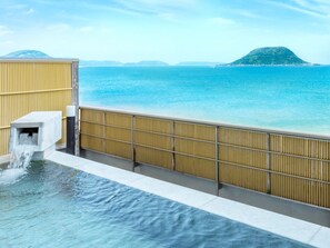 A spa area with a water feature and a view of the sea. - Karatsu Seaside Hotel (Karatsu)