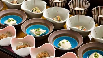 A variety of small bowls with different colored liquids and garnishes, arranged on a tray.