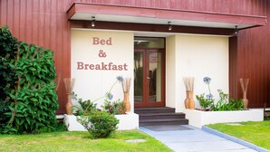 Un edificio con un letrero que dice "Bed & Breakfast" y una puerta con un letrero que dice "Acceso Solo Pasajeros".