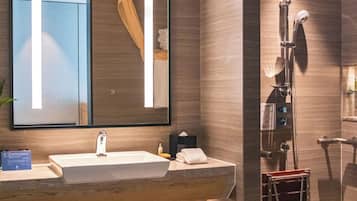 A modern bathroom with a large mirror, a sink, and a shower area.