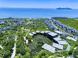 A resort with modern buildings, a central water feature, and a view of the ocean. - Grand Hyatt Sanya Haitang Bay Resort and Spa (Sanya)