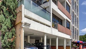 A multi-story building with a parking garage, large windows, and a modern architectural design. - Grupo Kings Suites Alfredo de Musset (Mexico City)