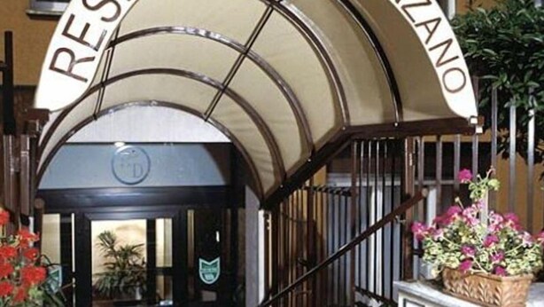 A hotel entrance with a curved awning and a sign that reads "RESIDENZANO". - Residence Desenzano (Milan)