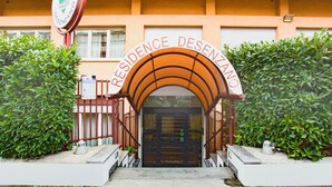 A building entrance with a sign reading 'RESIDENCE DESENZANO' and a gated entrance. - Residence Desenzano (Milan)
