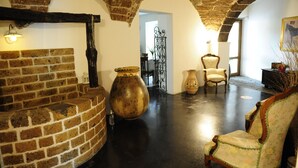 A room with a brick fireplace, a large vase, a wooden chair, and a lamp. - Sa Mola (Bonarcado)