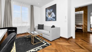A modern living room with a grey sofa, black and white patterned cushions, a glass coffee table, and a black and white rug. - Hotel 32One (San Francisco)