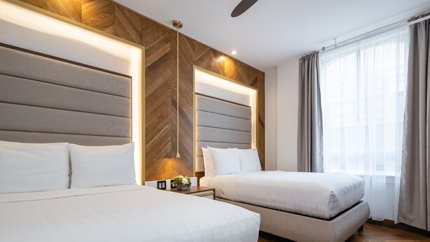 A hotel room with two beds, a wooden accent wall, a ceiling fan, and a large window with curtains. - Hotel 32One (San Francisco)