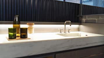 A modern kitchen with a marble countertop, a sink, and a window with a view of the city.