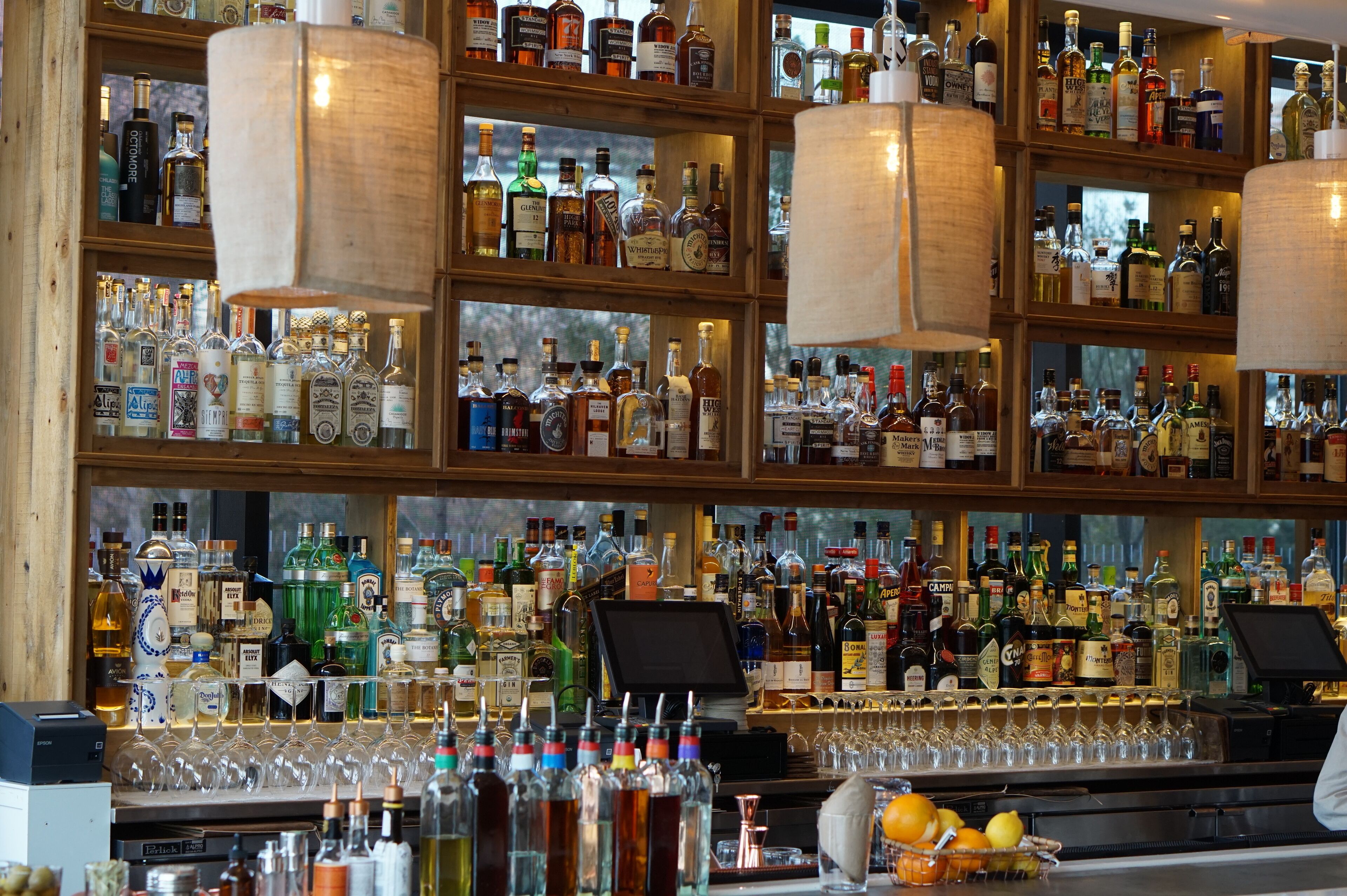 Eine Bar mit Regalen voller verschiedener Spirituosenflaschen und Gläser.