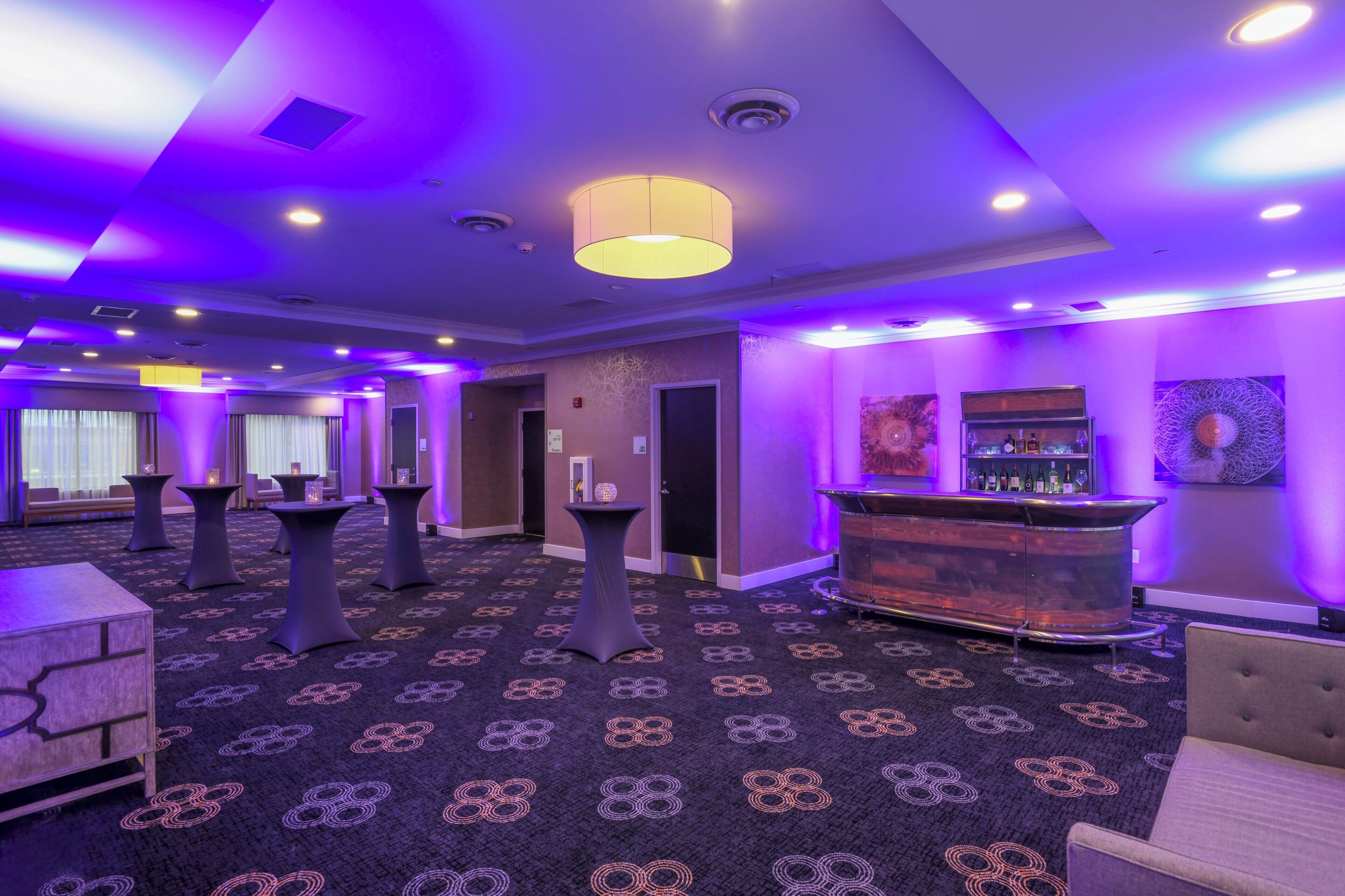 A hotel lobby with a reception desk, seating areas, and a patterned carpet.