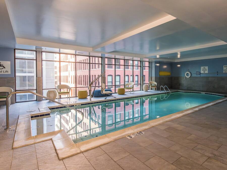 Piscina interior com paredes de vidro transparente, elevador de piscina e posto de salva-vidas.