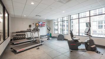 Un gimnasio con cintas de correr, mancuernas y equipo de ejercicio.