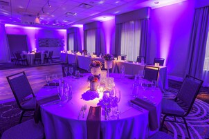 Comedor de hotel con mesas redondas, sillas y una barra de buffet.