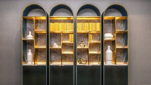A set of three arched bookshelves with decorative items and books, set against a plain wall. - voco The Clair Cincinnati Downtown by IHG (Cincinnati)