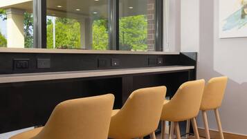 Un intérieur moderne avec un long comptoir et trois chaises jaunes.