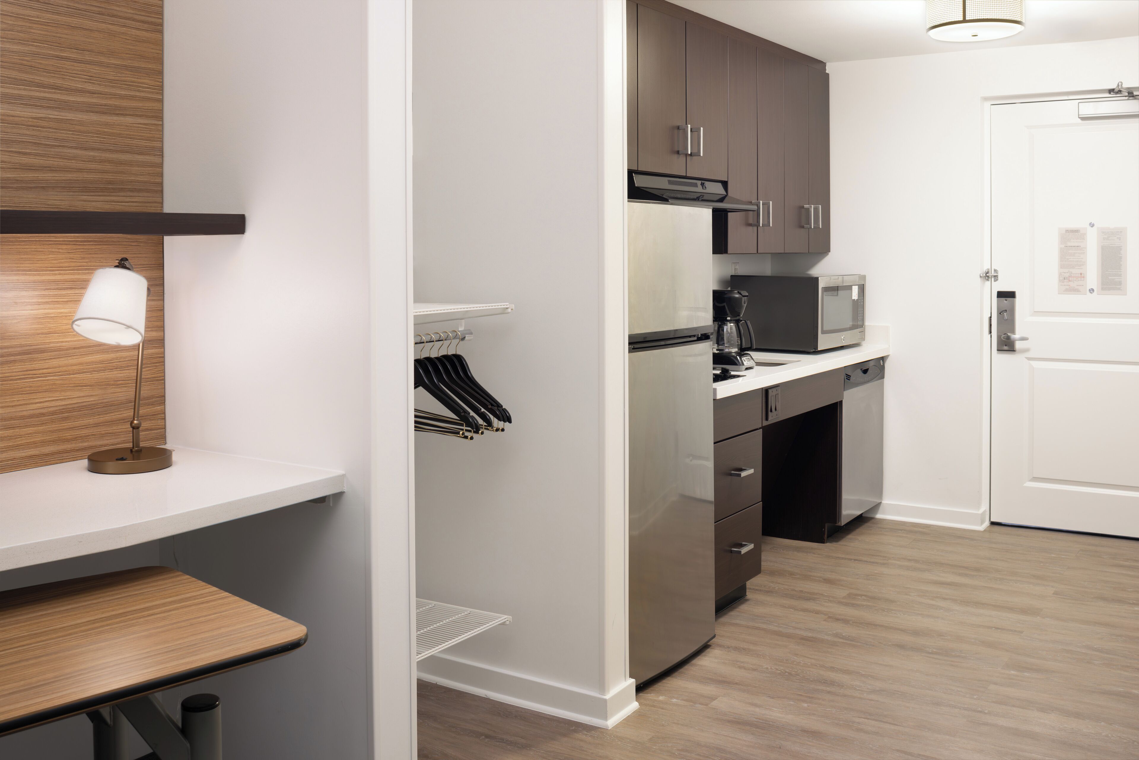 A modern kitchen with a built-in microwave, a coffee maker, and a refrigerator.