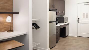 A modern kitchen with a built-in microwave, a coffee maker, and a refrigerator.